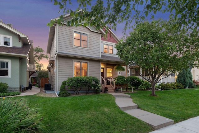 view of front of house featuring a yard and cooling unit