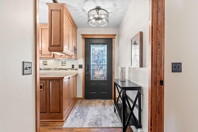 foyer featuring a chandelier, light wood-type flooring, and a textured wall