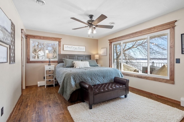 bedroom featuring visible vents, multiple windows, baseboards, and wood finished floors