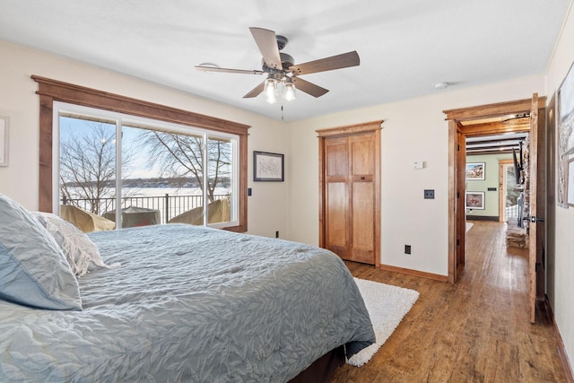 bedroom with baseboards, wood finished floors, a ceiling fan, and access to outside