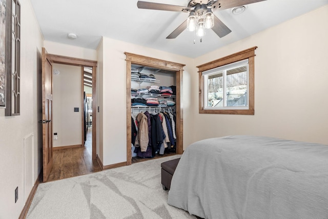 carpeted bedroom featuring a closet, baseboards, and ceiling fan