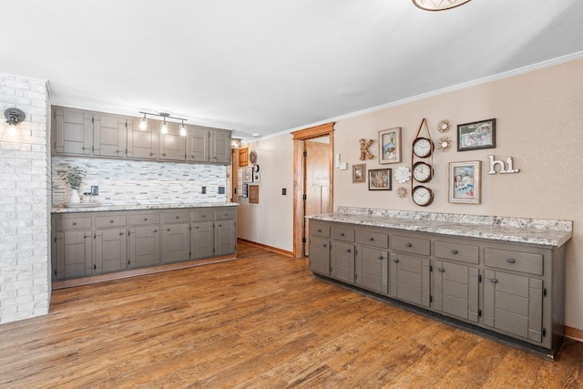 kitchen featuring crown molding, light countertops, gray cabinets, and light wood-type flooring