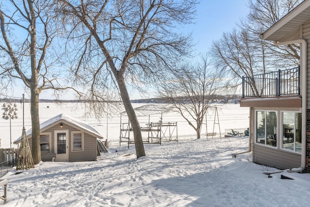 yard covered in snow with a balcony