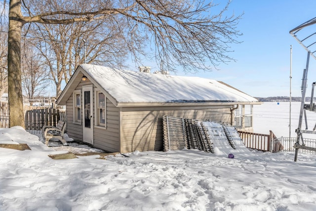 snow covered structure with fence