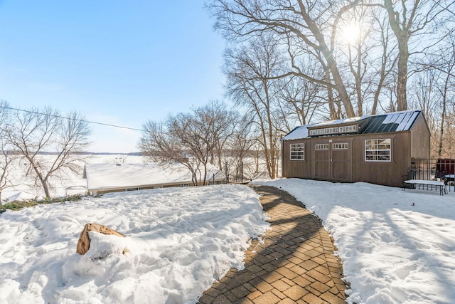 yard layered in snow featuring an outdoor structure