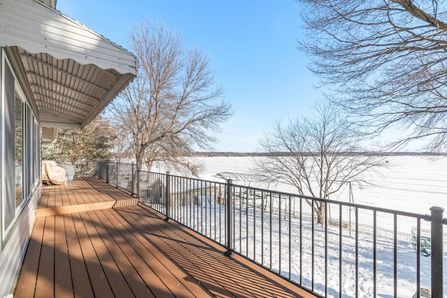 snow covered deck featuring a water view