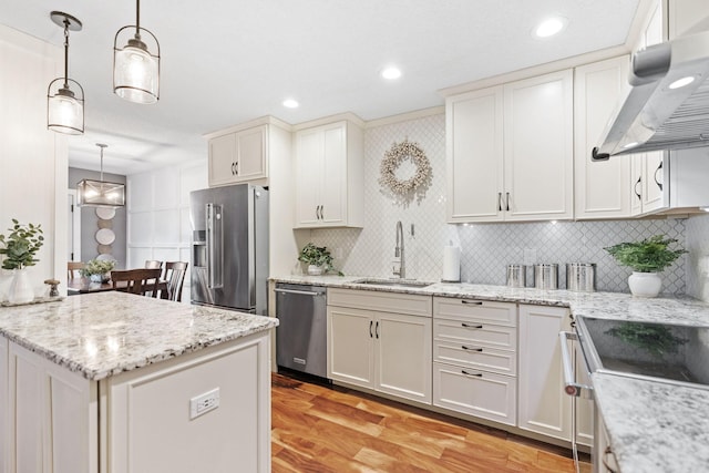 kitchen with backsplash, stainless steel appliances, extractor fan, and a sink