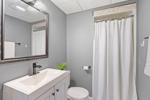 bathroom with vanity, a shower with curtain, toilet, and a paneled ceiling