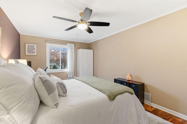 bedroom with baseboards, ceiling fan, ornamental molding, and wood finished floors