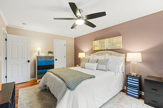 bedroom featuring baseboards, ornamental molding, a ceiling fan, and wood finished floors