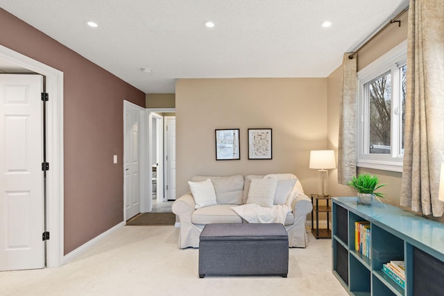 sitting room featuring baseboards, light carpet, recessed lighting, and a textured ceiling