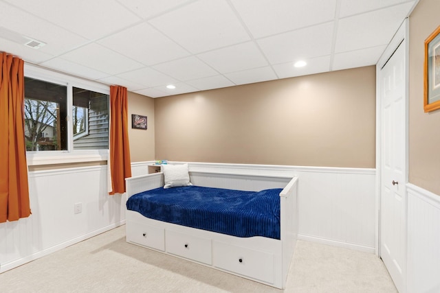bedroom with carpet floors, recessed lighting, wainscoting, and a paneled ceiling