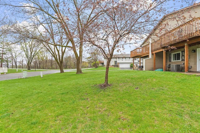 view of yard with a wooden deck and central AC
