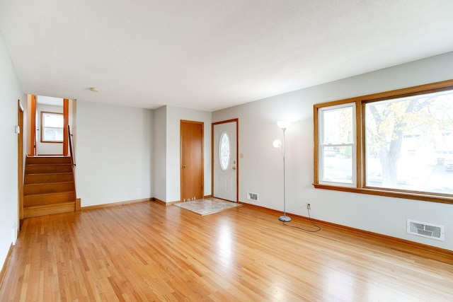 interior space featuring light wood-type flooring, baseboards, and visible vents