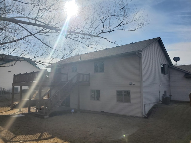 rear view of property featuring central AC, a deck, stairs, and a shingled roof