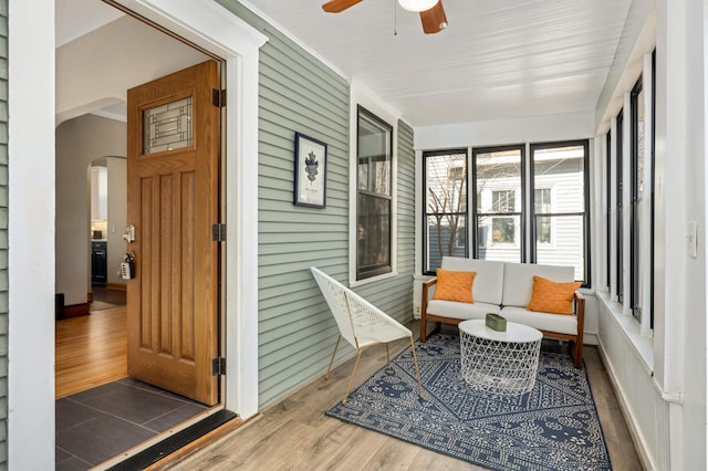 sunroom / solarium with arched walkways and a ceiling fan