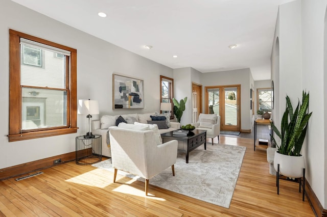 living room featuring recessed lighting, light wood-style floors, visible vents, and baseboards