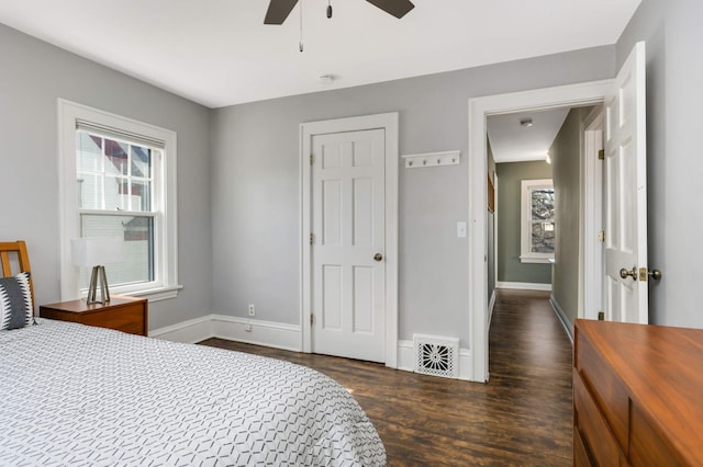 bedroom with a ceiling fan, wood finished floors, visible vents, and baseboards