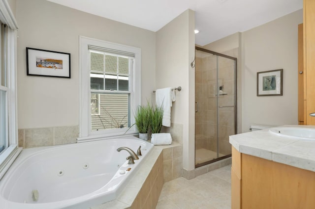 full bathroom featuring tile patterned flooring, a jetted tub, vanity, and a stall shower