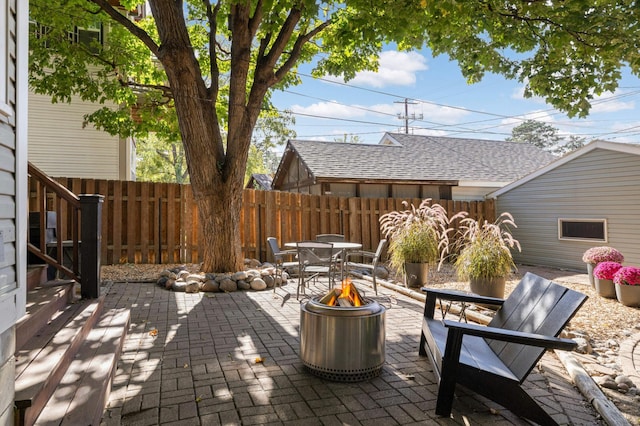 view of patio / terrace featuring an outdoor fire pit and fence