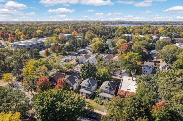 drone / aerial view featuring a water view, a forest view, and a residential view