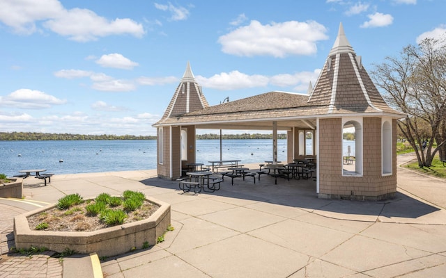 surrounding community featuring a gazebo, a patio area, and a water view