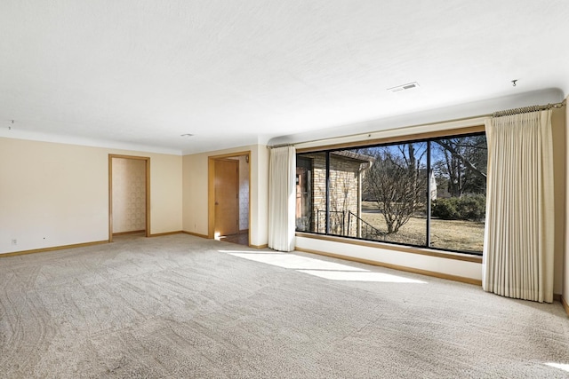 spare room featuring baseboards, carpet floors, and visible vents