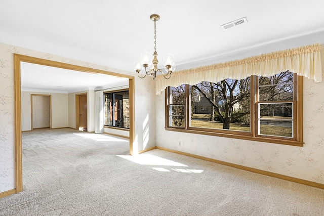 empty room with a wealth of natural light, visible vents, wallpapered walls, and carpet