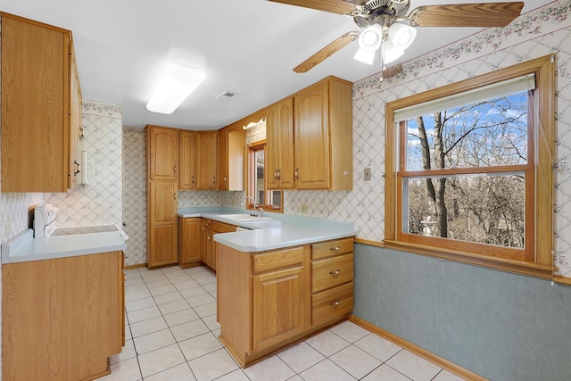 kitchen with a peninsula, wallpapered walls, and a sink