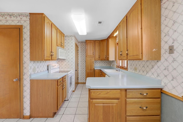 kitchen featuring white appliances, light tile patterned floors, wallpapered walls, a sink, and light countertops