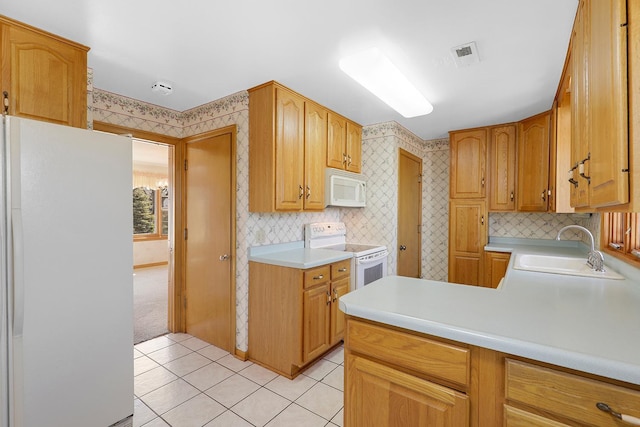 kitchen with visible vents, a sink, white appliances, wallpapered walls, and light countertops