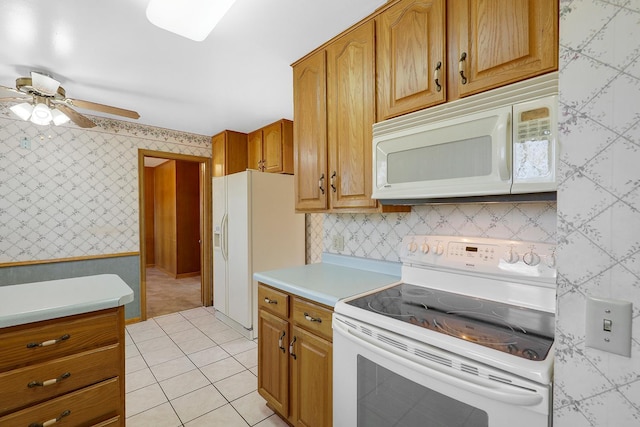 kitchen featuring white appliances, a ceiling fan, wallpapered walls, light tile patterned flooring, and light countertops