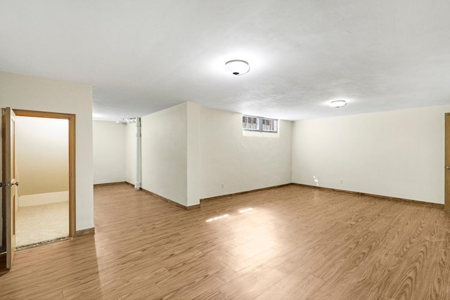 basement with light wood-type flooring and baseboards