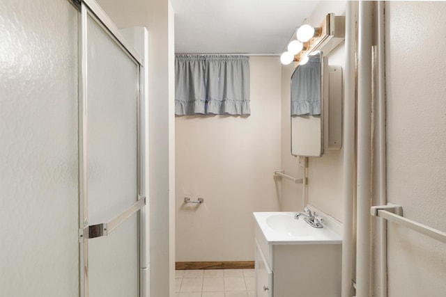 bathroom featuring tile patterned floors, a stall shower, vanity, and baseboards