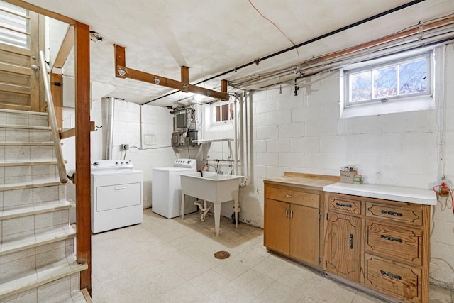 below grade area with washer and dryer, stairway, light floors, and a sink