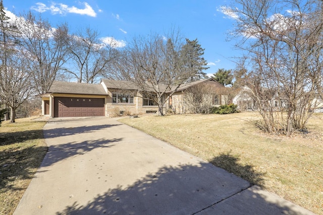 view of front of house with stone siding, a front yard, an attached garage, and driveway