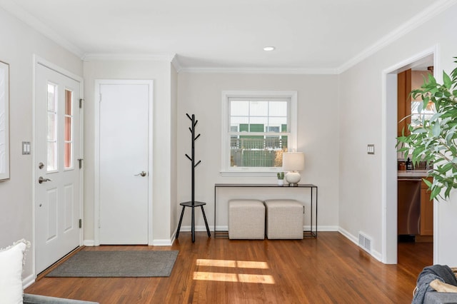 entrance foyer featuring baseboards, crown molding, visible vents, and wood finished floors