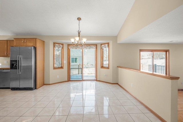 kitchen featuring appliances with stainless steel finishes, lofted ceiling, baseboards, and light tile patterned floors