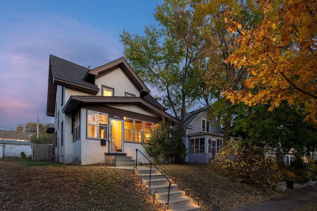 view of front facade with fence and stucco siding