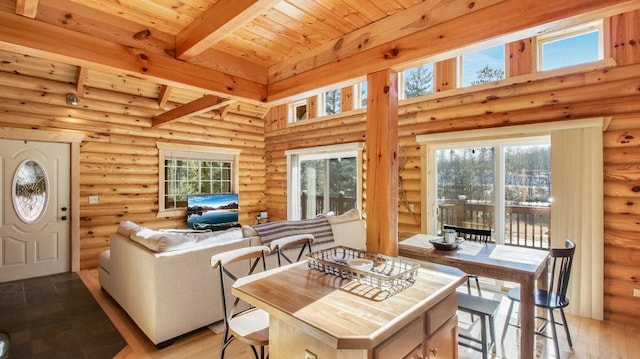 dining area with beam ceiling, wooden ceiling, light wood-type flooring, and a wealth of natural light