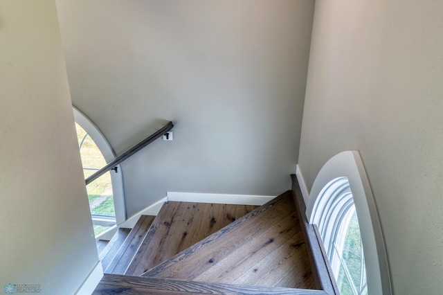 staircase featuring wood-type flooring and baseboards