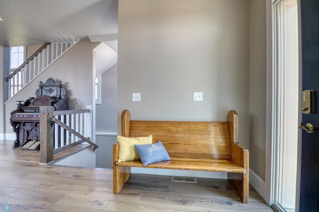 interior space featuring baseboards, an upstairs landing, and wood finished floors