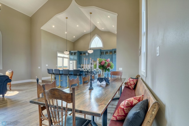 dining area featuring high vaulted ceiling, recessed lighting, light wood-type flooring, and baseboards