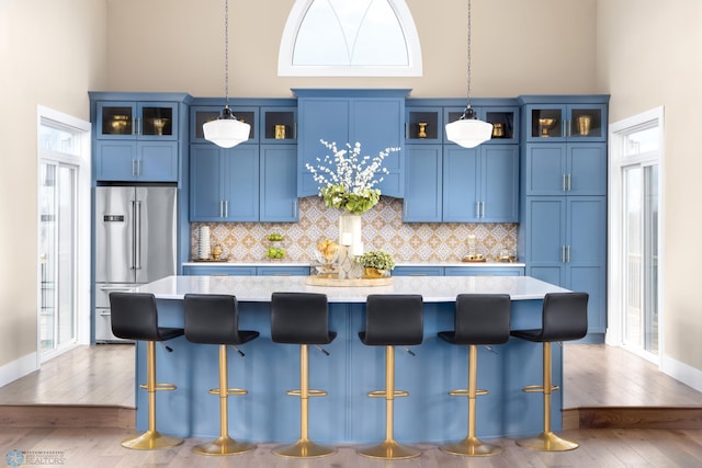 kitchen with a center island, light countertops, high quality fridge, and blue cabinetry