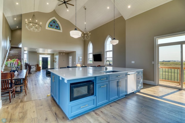 kitchen featuring light wood-type flooring, open floor plan, a sink, and blue cabinetry