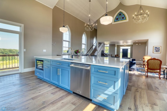 kitchen featuring blue cabinets, a notable chandelier, a sink, and stainless steel dishwasher