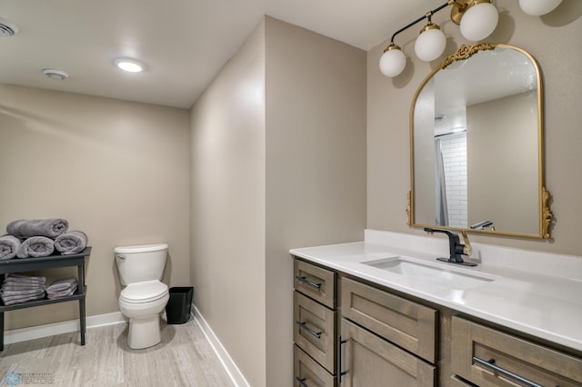 bathroom with toilet, wood finished floors, visible vents, vanity, and baseboards