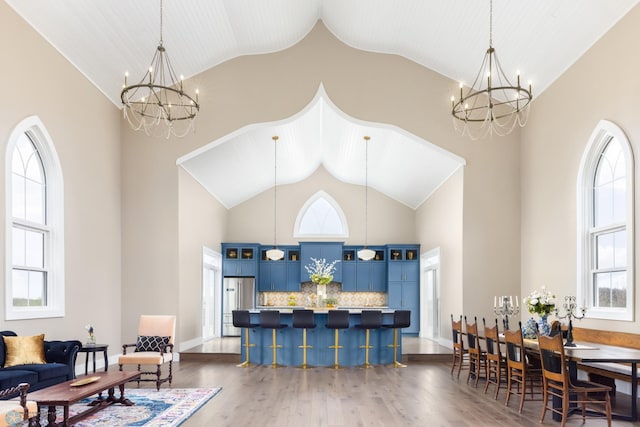 interior space with a chandelier, high vaulted ceiling, baseboards, and dark wood-style floors