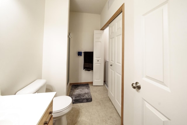 full bath featuring tile patterned flooring, toilet, vanity, a closet, and a shower stall