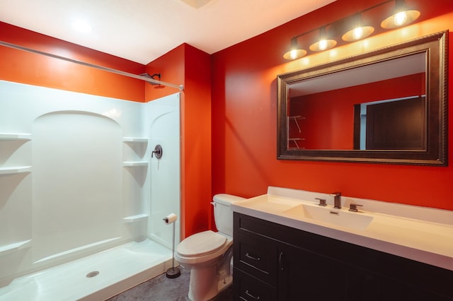 full bathroom with a stall shower, vanity, and toilet